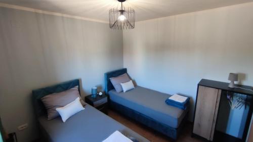 a room with two beds and a tv and a chandelier at Modern apartment in Biograd na Moru