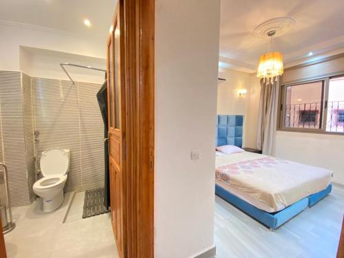 ein Schlafzimmer mit einem Bett und ein Badezimmer mit einem WC in der Unterkunft Sabor Family Aparts JAWHARAT AL ATLAS in Marrakesch