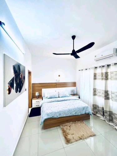 una camera con letto e ventilatore a soffitto di Charly-duplexben a Cotonou