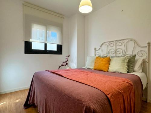 a bedroom with a bed with an orange blanket at Misterhost Triana Remedios 2BR & parking in Seville