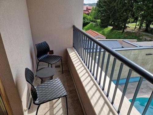 a balcony with two chairs and a swimming pool at Hotel Bernarda in Varaždinske Toplice