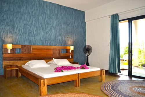 ein Schlafzimmer mit einem Bett mit lila Blumen darauf in der Unterkunft Kily House in Morondava