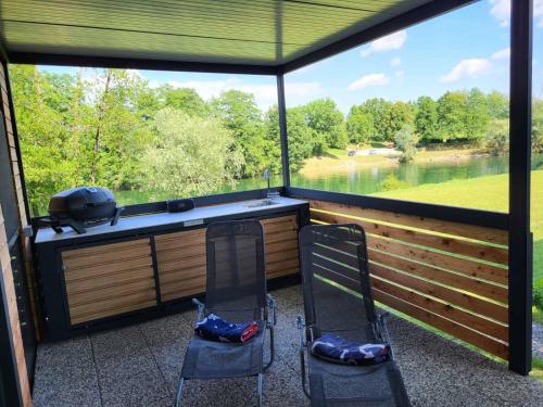 une véranda avec 2 chaises et une grande fenêtre dans l'établissement KOLPA - Luxury Natura House, à Gradac