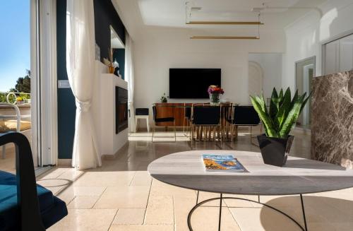 a living room with a table and a tv at Roberhouse Tragara 37 in Capri