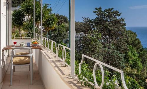 a balcony with a table and a view of the ocean at Roberhouse Tragara 37 in Capri