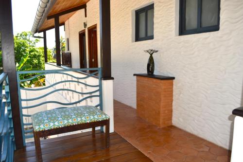 a balcony with a chair and a vase on a table at Kily House in Morondava