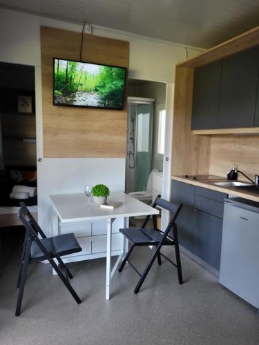 a small kitchen with a white table and chairs at KOLPA - Luxury Natura House in Gradac
