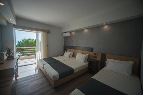 Habitación de hotel con 2 camas y ventana en Pappas Hotel, en Loutraki