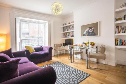 a living room with a purple couch and a table at 7 Mount Sion in Royal Tunbridge Wells