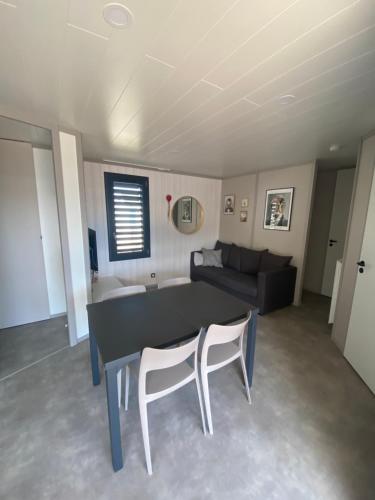 a living room with a table and chairs and a couch at Cottage "SANS SOUCI" chaleureux à 150m de la plage in Jullouville-les-Pins