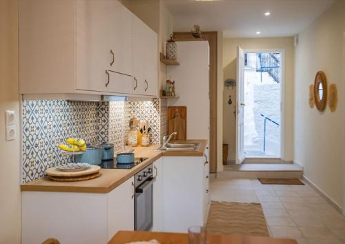a kitchen with white cabinets and bananas on the counter at Casa Artemisia in Kalymnos