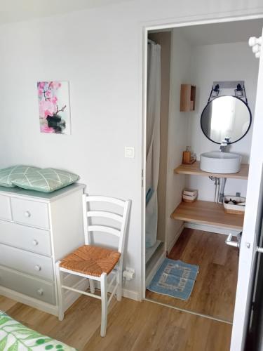 - une chambre avec une commode, une chaise et un miroir dans l'établissement Duplex face océan T2 + mezzanine à Bretignolles sur mer, à Bretignolles-sur-Mer