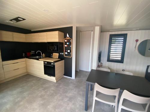 a kitchen with a table and chairs in a room at Cottage "SANS SOUCI" chaleureux à 150m de la plage in Jullouville-les-Pins