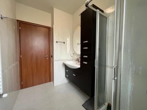 a bathroom with a sink and a shower with a mirror at Azzurro Horizon Apartment in Bellaria-Igea Marina