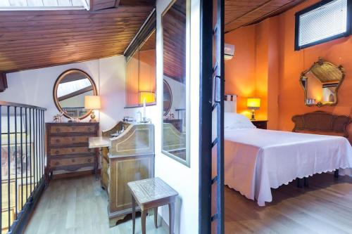 Un dormitorio con una cama grande y un espejo. en Pretty loft Viterbo medieval town, en Bagnaia