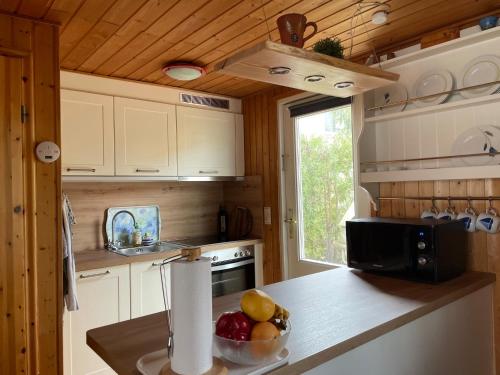 a kitchen with a counter with a bowl of fruit at Vogtis Ferienhaus am Glammsee in Warin