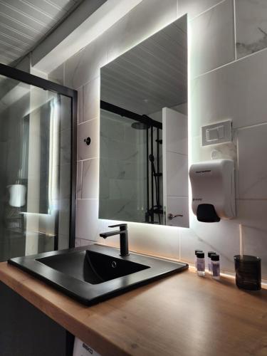 a bathroom with a black sink and a mirror at District Apartment in Bitola