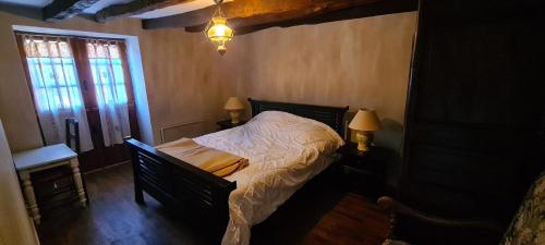 - une chambre avec un lit, deux lampes et une fenêtre dans l'établissement La Guelta, à Saint-Alvère