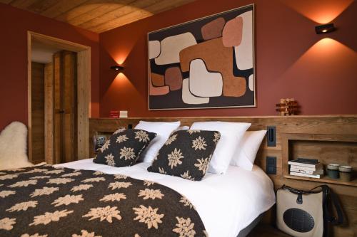 a bedroom with a bed with pillows and a painting at Chalet Fabriel in Montgenèvre