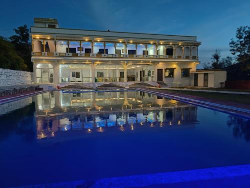 uma casa grande com piscina à noite em Monkey Retreat Resort em Udaipur