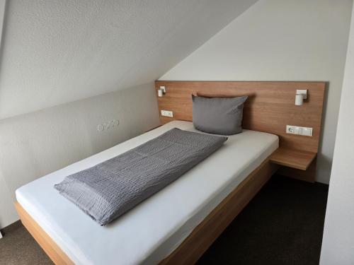 Bett in einem kleinen Zimmer mit in der Unterkunft Hotel Landgasthof Blume in Lichtenau