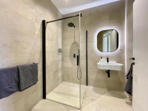 a bathroom with a shower and a sink at Bugibba Square Seafront LUX Apartments by Holi in St Paul's Bay
