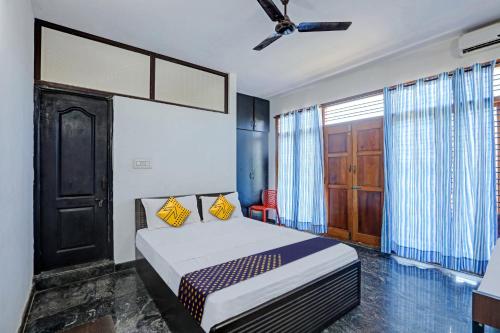1 dormitorio con 1 cama y ventilador de techo en SPOT ON Sri Durga Residency Hd Kote, en Mysore