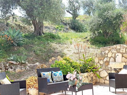a patio with a couch and chairs in a garden at Appartamento Castel Sant'Angelo in Licata