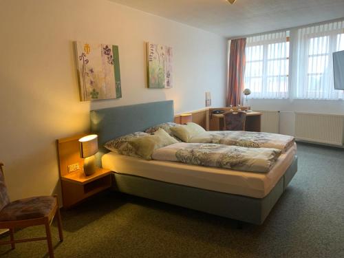 a bedroom with a large bed in a room at Hotel Alt Oesselse in Hannover