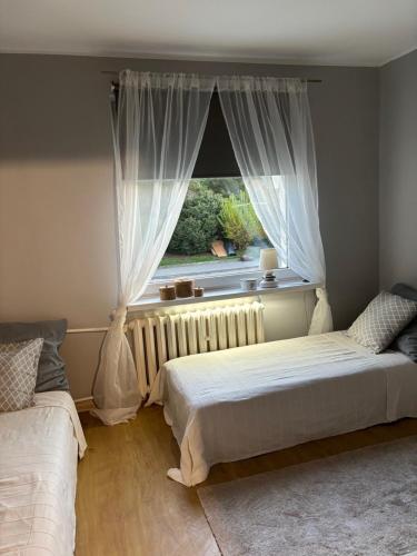 a bedroom with two beds in front of a window at Gdynia Apartament Torpedownia in Gdynia