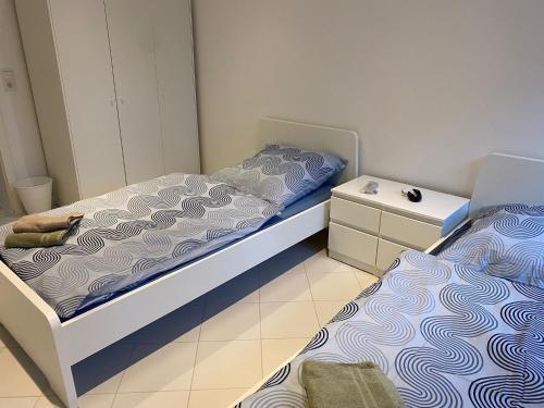 a bedroom with two beds and a night stand at Möbilierte 2-Zimmerwohnung mit geräumiger Wohnküche in Ludwigshafen am Rhein