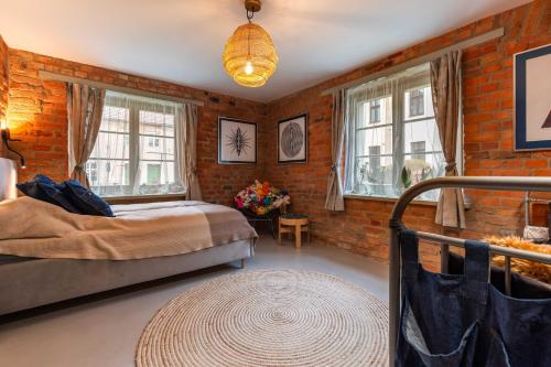 a bedroom with a bed and windows and a rug at Reszel Art House in Reszel