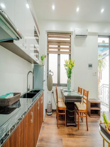 a kitchen with a table and chairs and a sink at Căn villa Homestay 12 phòng ngủ - bể bơi - Trung tâm Bãi Cháy in Ha Long
