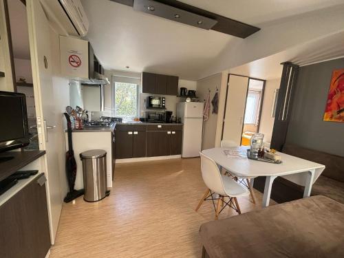 - une cuisine avec une table et une table et des chaises blanches dans l'établissement A Casa Di l'Altana, à Porto-Vecchio