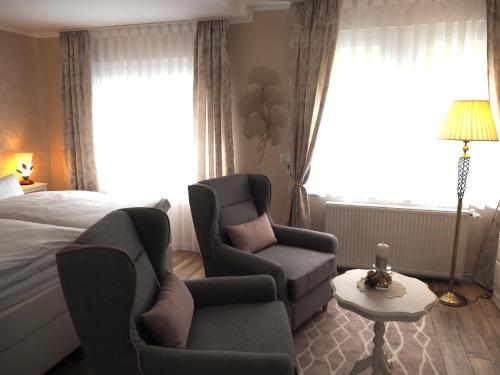a bedroom with a bed and two chairs and a table at Apartment Schlossblick - Top location in Idar-Oberstein