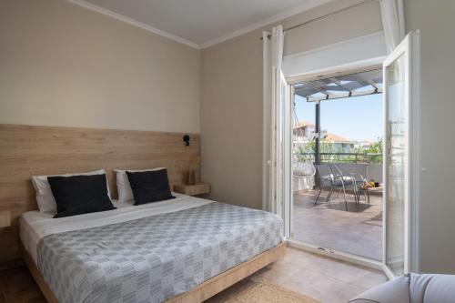 a bedroom with a bed and a sliding glass door at StayInn Luxury Apartments in Nea Kalikratia