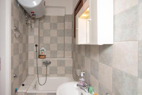 a bathroom with a sink and a toilet and a tub at Potami Mountain in Karlovasi