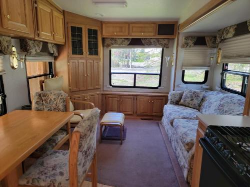 a kitchen and living room of an rv at Camping Beaurivage 2-Pret à camper pour 4 personnes in Routhierville