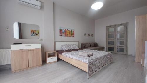 een slaapkamer met een bed en een flatscreen-tv bij Apartment in Arkadia in Odessa