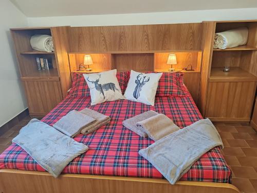 a bed with three pillows and a plaid blanket at Villa Chalet Bellagio Panorama in Bellagio