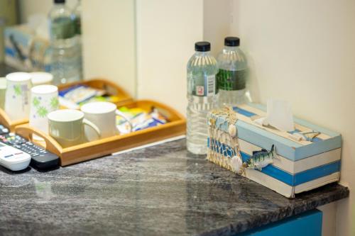 - un comptoir avec un plateau avec des tasses et des bouteilles d'eau dans l'établissement Rainbow B&B, à Dahan