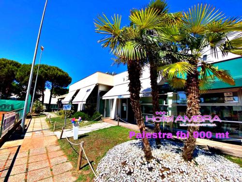 two palm trees in front of a building at HOTEL AMBRA - Fronte Mare - Vicinissimi al Centro in Milano Marittima