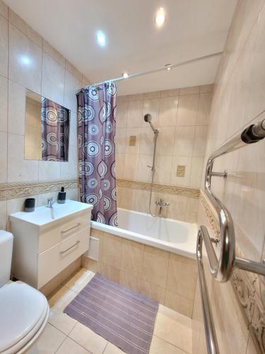 ein Badezimmer mit einer Badewanne, einem WC und einem Waschbecken in der Unterkunft Giedres Kalnieciu apartments in Kaunas