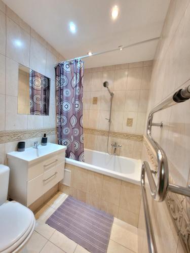 a bathroom with a tub and a toilet and a sink at Giedres Kalnieciu apartments 1 in Kaunas
