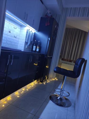 eine Küche mit einem Stuhl in einem Zimmer mit Beleuchtung in der Unterkunft RentHUB apartment in Chişinău