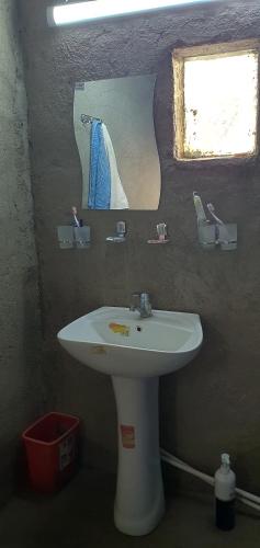 a bathroom with a white sink and a mirror at Kakhar Yurt stay & Mountain village in Sentyab