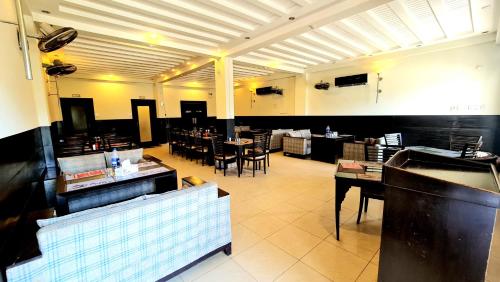 une salle à manger avec des tables et des chaises dans un restaurant dans l'établissement Shelton Hotel & Restaurant, à Sarai