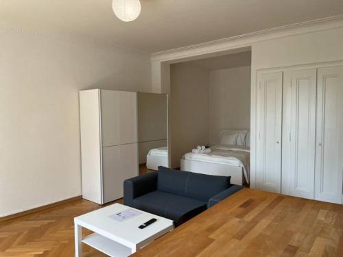 a living room with a blue couch and a bed at Studio ensoleillé avec balcon in Lausanne