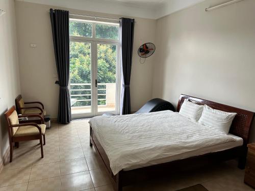 1 dormitorio con cama y ventana grande en Thiên Bình Hotel, en Hòa Bình