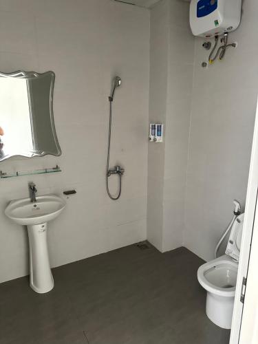 biała łazienka z umywalką i toaletą w obiekcie Thiên Bình Hotel w mieście Hòa Bình